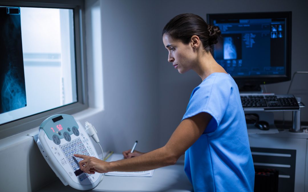 Nurse taking notes in x-ray room at hospital